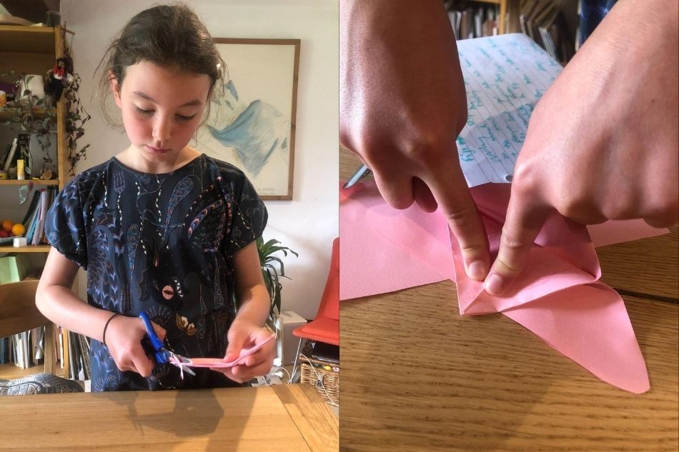 Pige laver hjemmelavet origami kattelegetøj